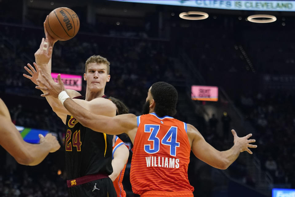 Cleveland Cavaliers' Lauri Markkanen (24) passes over Oklahoma City Thunder's Kenrich Williams (34) in the first half of an NBA basketball game, Saturday, Jan. 22, 2022, in Cleveland. (AP Photo/Tony Dejak)