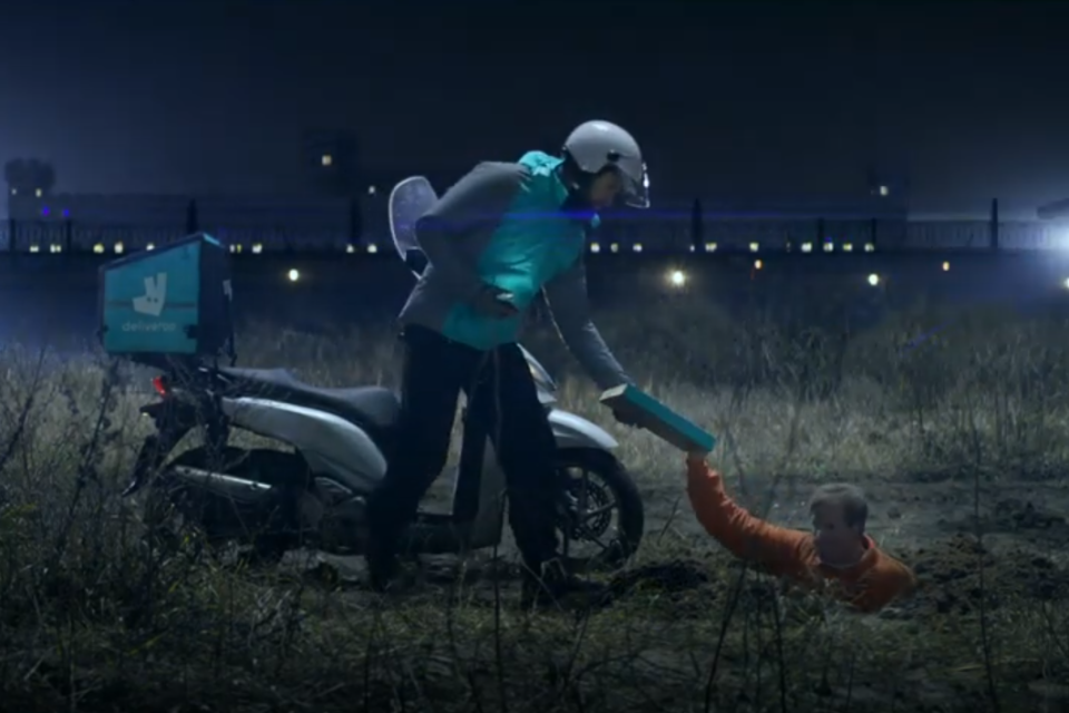 A customer is shown receiving a delivery in a field after apparently tunnelling under-ground to escape from prison: Deliveroo