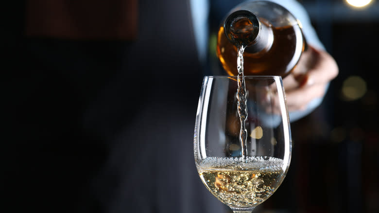 Glass of white wine being poured