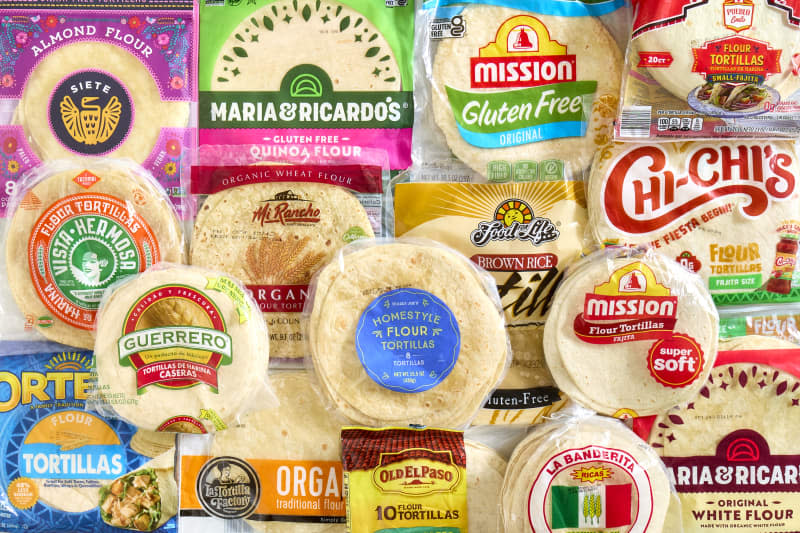 overhead shot of all the different brands of flour tortillas stacked on each other