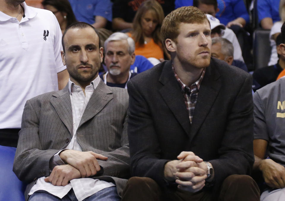 San Antonio Spurs' Manu Ginobili, left, and Matt Bonner, right, sit on the bench during an NBA basketball game against the Oklahoma City Thunder in Oklahoma City, Thursday, April 3, 2014. Oklahoma City won 106-94. (AP Photo/Sue Ogrocki)