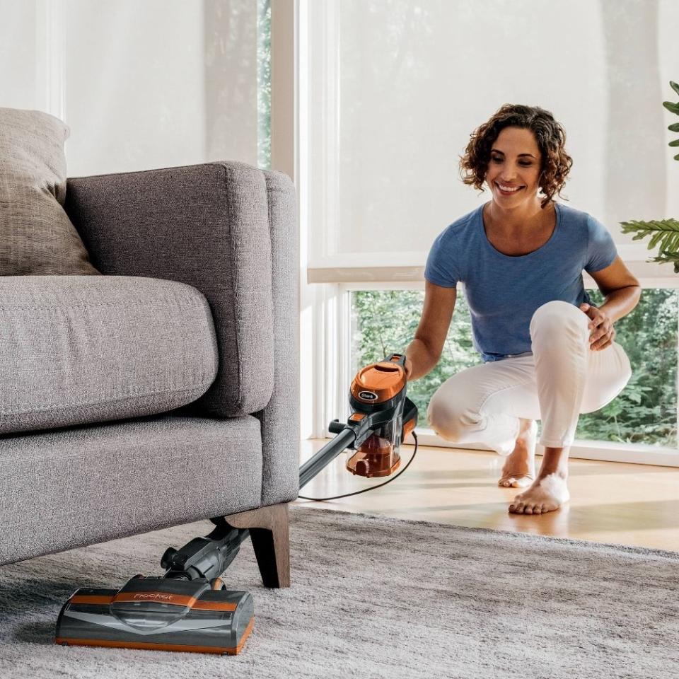 model vacuuming under the couch