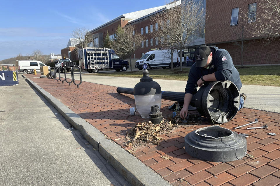 A street light is repaired at UConn in Storrs, Conn., Tuesday, April 4, 2023. Thousands of UConn fans, most of them students, spilled onto campus after watching a broadcast of the Huskies’ NCAA Tournament win over San Diego State, Monday night, with some pulling down signs and light poles, smashing windows and causing other damage. (AP Photo/Pat Eaton-Robb)