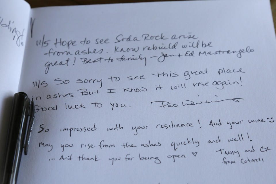 This Wednesday, Nov. 6, 2019, photo, shows messages left in a guest book on the counter in a tasting area at the wildfire damaged Soda Rock Winery in Healdsburg, Calif. Despite a late October blaze that raged through one of the world's best-known wine-growing regions. forcing evacuations in two mid-sized towns, wine production in Sonoma County escaped largely unscathed. (AP Photo/Eric Risberg)