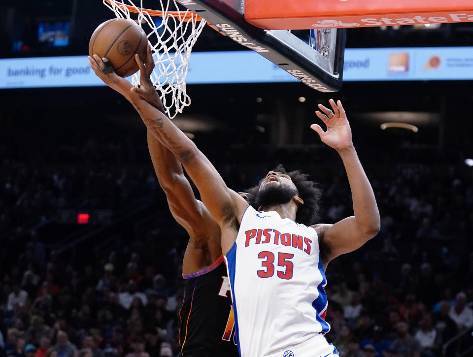 Phoenix Suns' Bismack Biyombo, left, tips the ball off the fingers of Detroit Pistons' Marvin Bagley III (35) during the first half of an NBA basketball game in Phoenix, Friday, Nov. 25, 2022. (AP Photo/Darryl Webb)