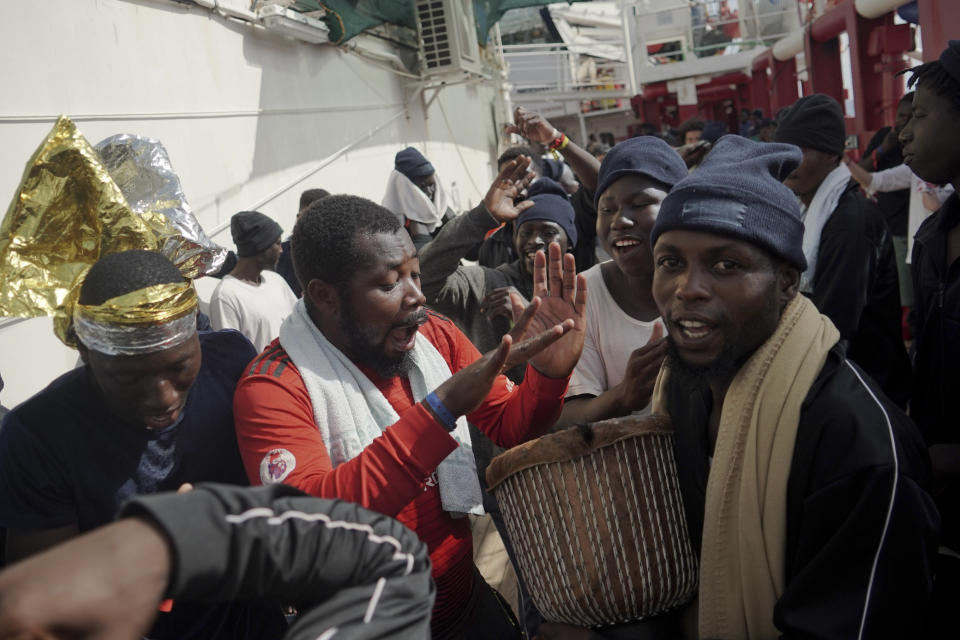 Migrants celebrate after receiving news of their assigned place of safety, aboard the Ocean Viking in the Mediterranean Sea, Monday, Sept. 23, 2019. Italy has granted the humanitarian ship permission to sail to the port of Messina in Italy to disembark 182 people rescued north of Libya. (AP Photo/Renata Brito)