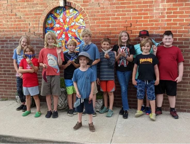 Children pose in front of the first mural installed in downtown Marshall, "Find Your Center," in July 2021.