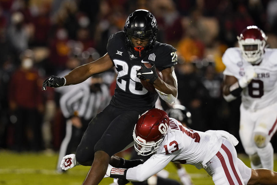 Iowa State running back Breece Hall (28) breaks a tackle by Oklahoma defensive back Tre Norwood (13) during the first half an NCAA college football game, Saturday, Oct. 3, 2020, in Ames, Iowa. (AP Photo/Charlie Neibergall)