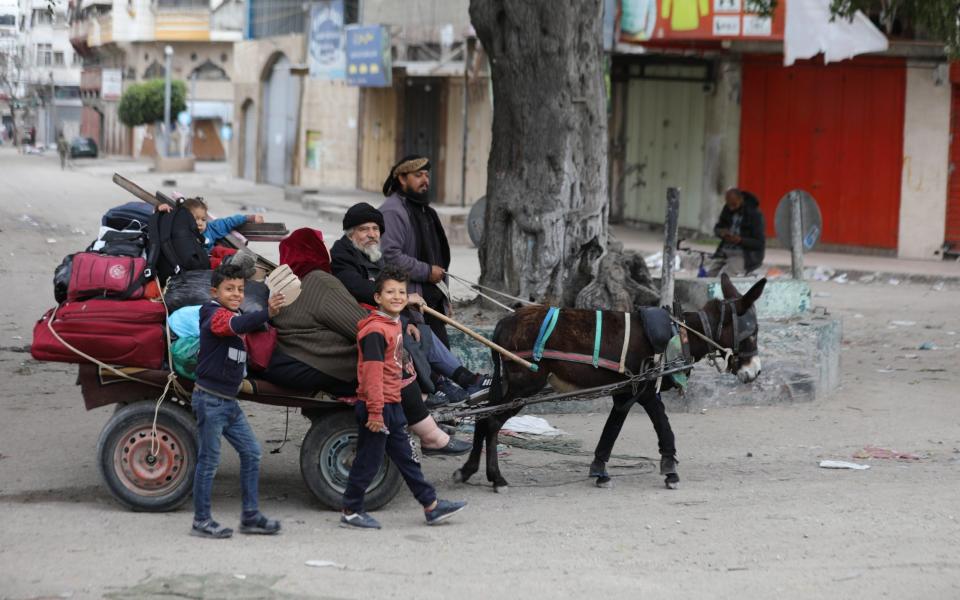 GAZA CITY, GAZA - MARCH 18: Palestinian residents leave the area with a few items after the Israeli army forces besiege the Al-Shifa hospital with tanks and heavy gunfire in Gaza City, Gaza on March 18, 2024. (Photo by Dawoud Abo Alkas/Anadolu via Getty Images)