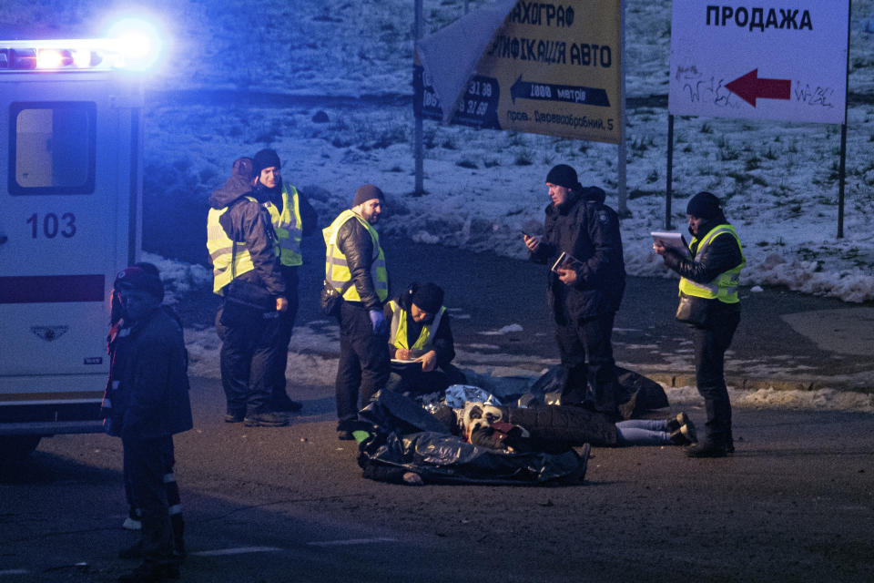 Police officers inspect corpses of people killed after a Russian rocket attack in Kyiv, Ukraine, Wednesday, Nov. 23, 2022. (AP Photo/Evgeniy Maloletka)