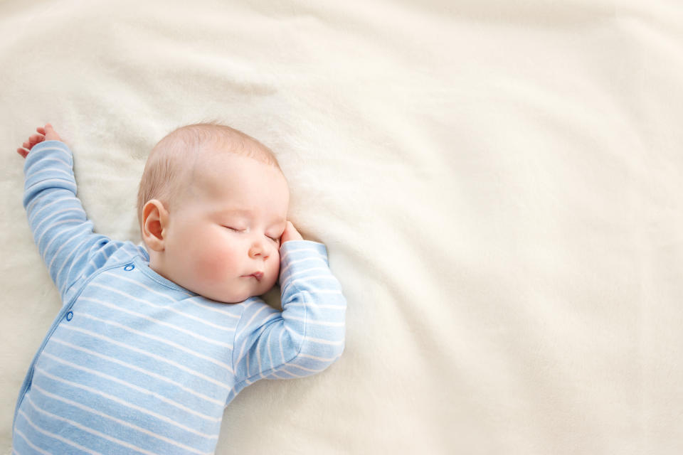 little boy sleeping on soft white blanket