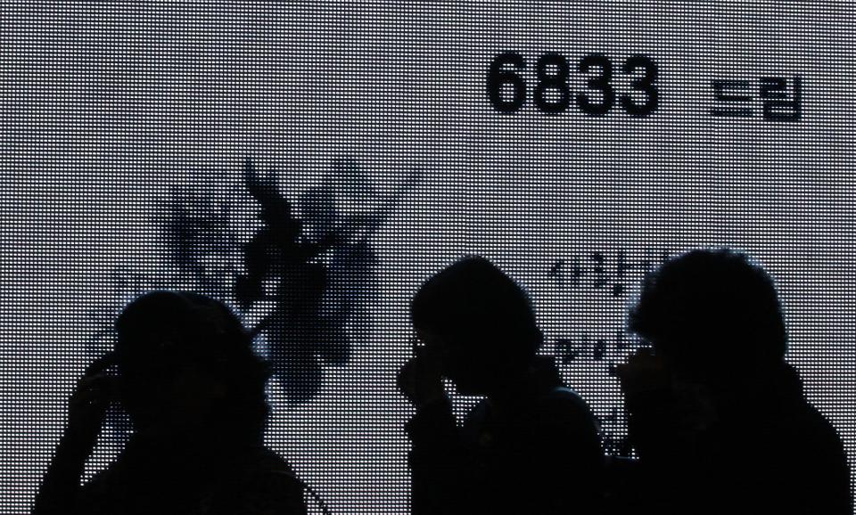 Crying women are silhouetted as they pay tribute to the victims of the sunken ferry Sewol at a group memorial altar in Ansan, South Korea, Saturday, May 3, 2014. More than 300 people are dead or missing in the disaster that has caused widespread grief, anger and shame. (AP Photo/Ahn Young-joon)