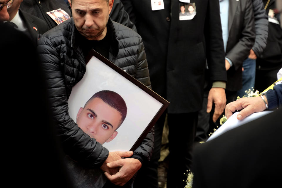 A man holds a portrait of a victim of the earthquake in Turkey, during a funeral procession in the Turkish occupied area in northeast coastal city of Famagusta, Cyprus, on Friday, Feb. 10, 2023. A funeral service was held in Famagusta city for Fahri Arkar, Mert Niyazi Topukcuoglu and brothers Doruk and Alp Akın, who perished in the ruins of their collapsed hotel in the Turkish city of Adiyaman. (AP Photo/Petros Karadjias)