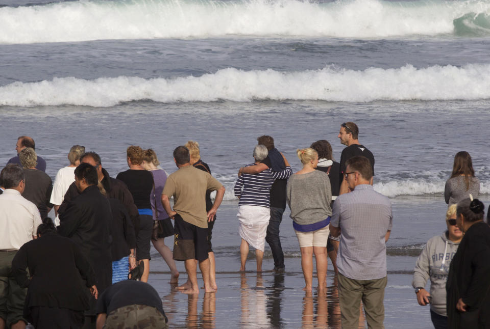 People gather on Muriwai Beach near Auckland, New Zealand, Thursday, Feb. 28, 2013, to say goodbye to Adam Strange. About 150 friends and family of Strange, 46, wrote messages to him in the sand and stepped into the water Thursday at a New Zealand beach to say goodbye after he was killed Wednesday by a large shark. (AP Photo/New Zealand Herald, Brett Phibbs) New Zealand Out, Australia Out