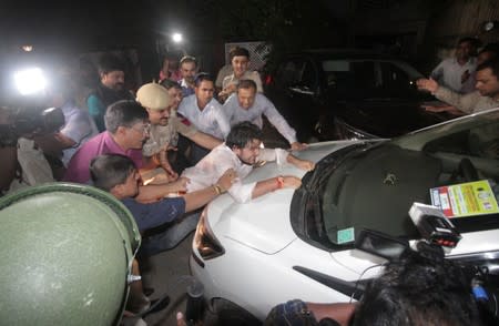 Supporter of India's former Finance Minister Chidambaram tries to stop a vehicle carrying Chidambaram after he was arrested by CBI officials in New Delhi