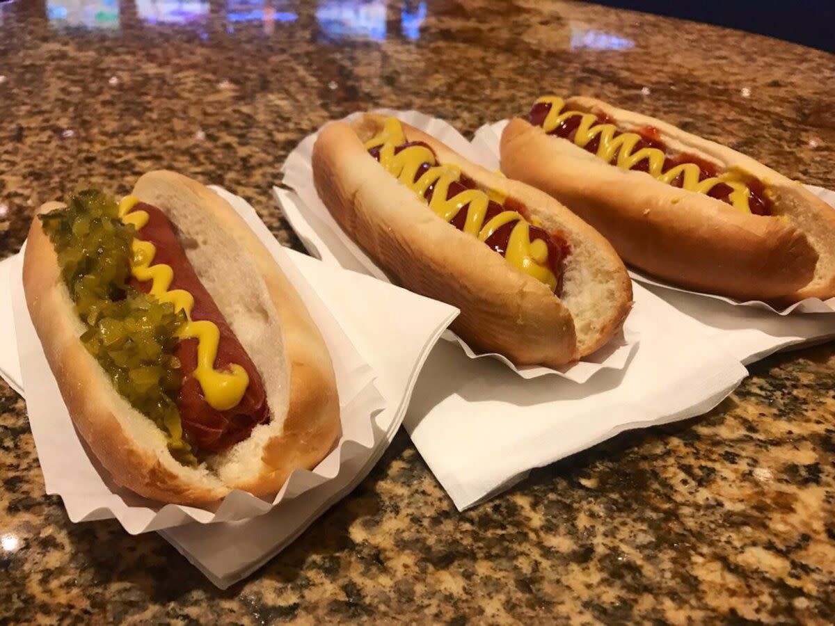 Three Budweiser-Steamed Dogs on individual white papers on a brown quartz table, South Point Hot Dog Cart, Las Vegas