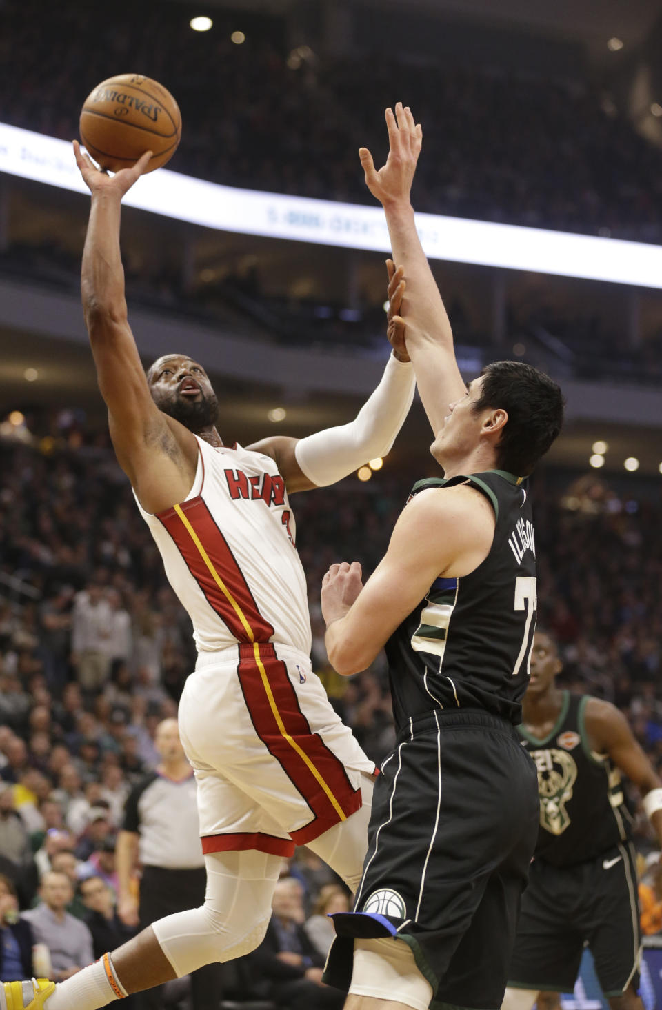 Miami Heat's Dwyane Wade, left, drives against Milwaukee Bucks' Ersan Ilyasova during the first half of an NBA basketball game Friday, March 22, 2019, in Milwaukee. (AP Photo/Jeffrey Phelps)