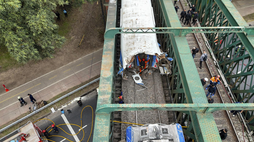 Railway workers inspect a passenger train after it collided with another in Buenos Aires, Argentina, Friday, May 10, 2024. (AP Photo/Franco Dergarabedian)