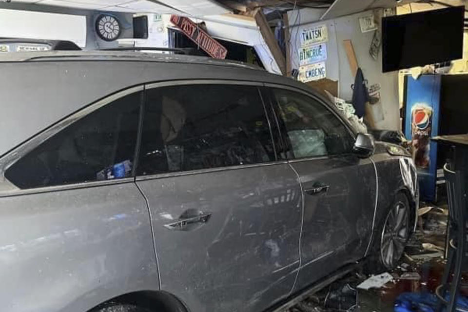In this photo released by the Laconia Fire Department, a vehicle sits inside a restaurant after crashing through the wall on Sunday, July 2, 2023, in Laconia, NH. The car struck the busy Looney Bin Bar & Grill and injured more than a dozen patrons inside, authorities said. (Laconia Fire Department via AP)