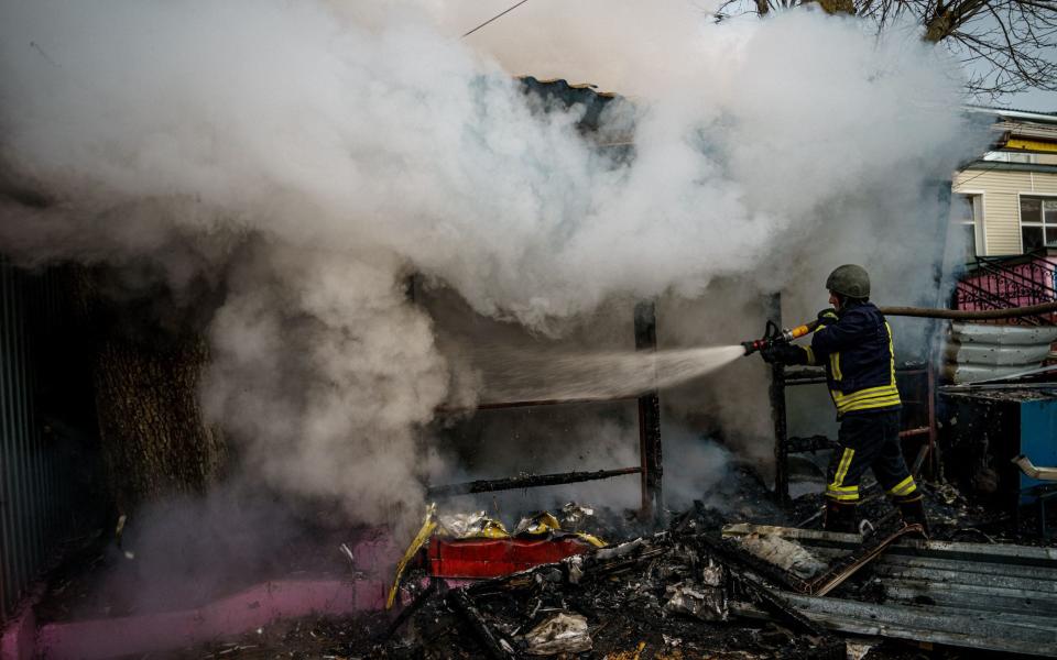 Un rescatista extingue un incendio en una tienda en llamas
