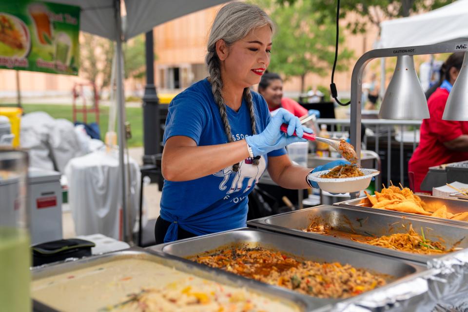 Tol Foskier serves pad Thai from Thai street food by Weenathe during the World Food and Music Festival in the Western Gateway Park, Friday, Aug. 25, 2023.
