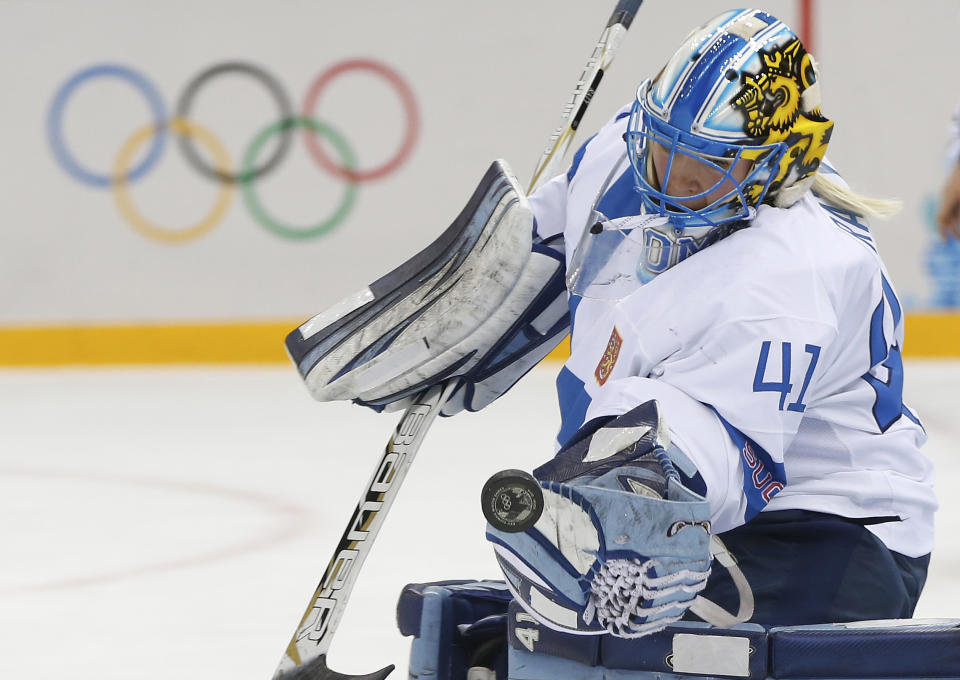 Goalkeeper Noora Raty of Finland reaches for the puck during the 2014 Winter Olympics women's quarterfinal ice hockey game against Sweden at Shayba Arena, Saturday, Feb. 15, 2014, in Sochi, Russia. (AP Photo/Petr David Josek)