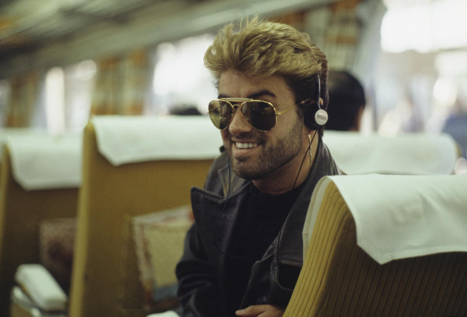 English singer and songwriter George Michael (1963-2016) pictured listening to a walkman personal stereo device on a bullet train during the Japanese leg of his Faith World Tour in February 1988. (Photo by Michael Putland/Getty Images)