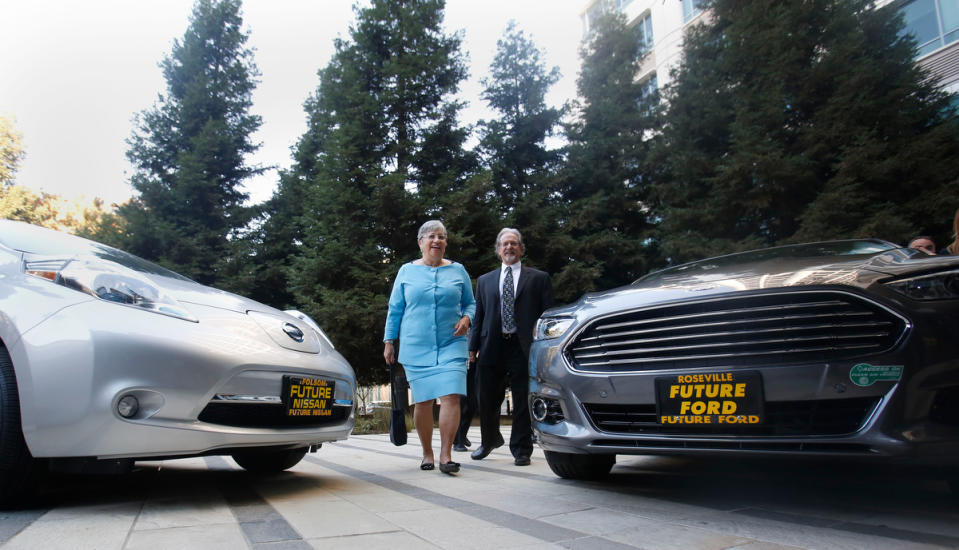 Mary Nichols, chairwoman of the California Air Resources Board, walks between a pair of zero-emission vehicles displayed in Sacramento, Calif., on Oct. 24, 2013.