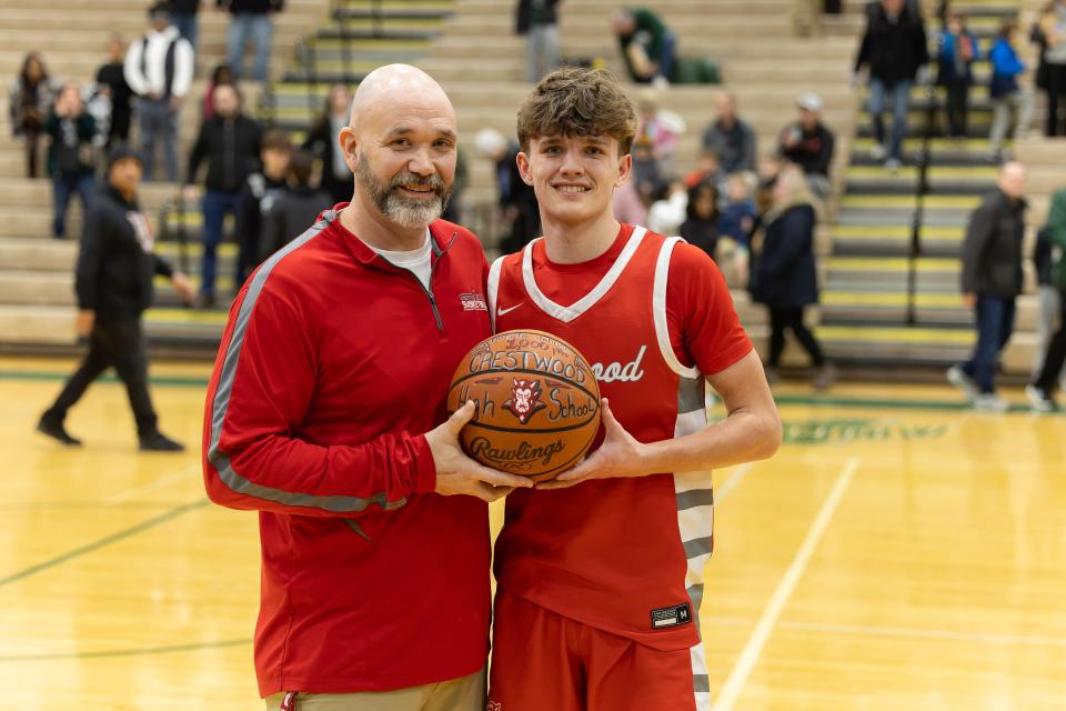 Crestwood head coach Josh Jakacki and junior Dekota Johnson celebrate Johnson’s 1,000th career point at the conclusion of Tuesday night’s basketball game in Aurora.