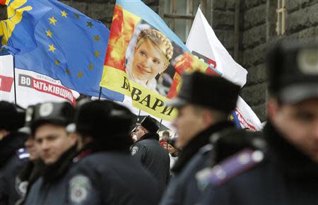 A portrait of jailed opposition leader Yulia Tymoshenko is seen on a flag during a rally to support EU integration in front of the Ukrainian cabinet of ministers building in Kiev November 26, 2013. REUTERS/Vasily Fedosenko