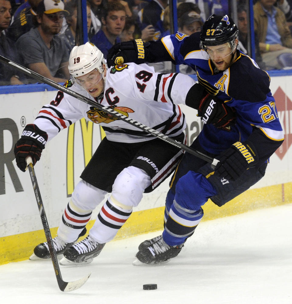 St. Louis Blues' Alex Pietrangelo (27) and Chicago Blackhawks' Jonathan Toews (19) battle for the puck during the first period in Game 2 of a first-round NHL hockey playoff series, Saturday, April 19, 2014, in St. Louis. (AP Photo/Bill Boyce)