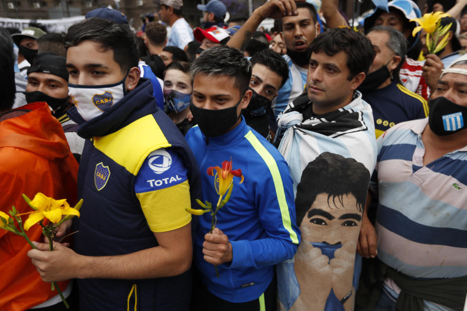 Soccer fans line up to see the casket with the body of Diego Maradona at the presidential palace in Buenos Aires, Argentina, Thursday, Nov. 26, 2020. The Argentine soccer great who was among the best players ever and who led his country to the 1986 World Cup title died from a heart attack at his home Wednesday, at the age of 60. (AP Photo/Natacha Pisarenko)