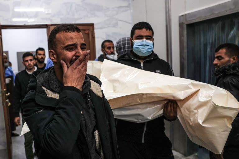 Dolientes transportan el cuerpo de un palestino, muerto durante un ataque israelí, desde el hospital de la UE en Khan Younis, en el sur de la Franja de Gaza, el 21 de diciembre de 2023.