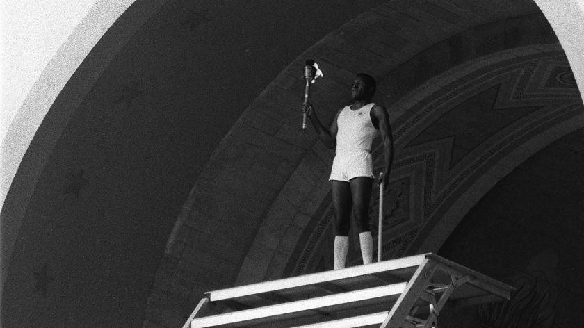 7/28/1984 – OLY LEGACY – Rafer Johnson lights the Olympic Flame at the Los Angeles Coliseum. FOR OLYMPIC LEGACY STORY BY ALAN ABRAHAMSON