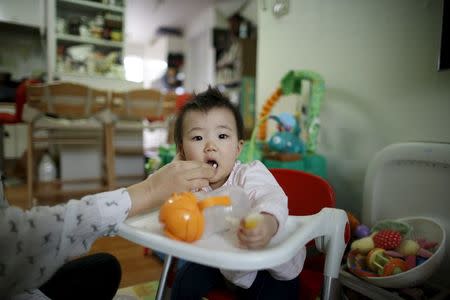 Jeong Bo-mi, 37, among a group of South Korean parents who sued a post-partum care centre seeking compensation after babies were infected with latent tuberculosis, takes care of her baby, who was not infected but was treated as a preventive measure, at her home in Seoul, South Korea, April 7, 2016. REUTERS/Kim Hong-Ji