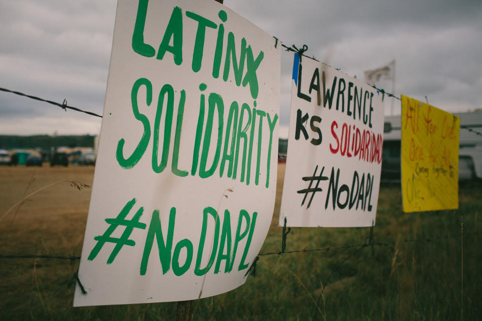 <p>Protest signs hang from barbed wire during a historic gathering of more than a hundred Native American tribes from across North America, rallying to stop the pipeline they fear will poison the Missouri River, which runs through the Standing Rock Sioux reservation on Bismarck, N. D., on Sept. 6, 2016. (Photo: Alyssa Schukar for Yahoo News) </p>