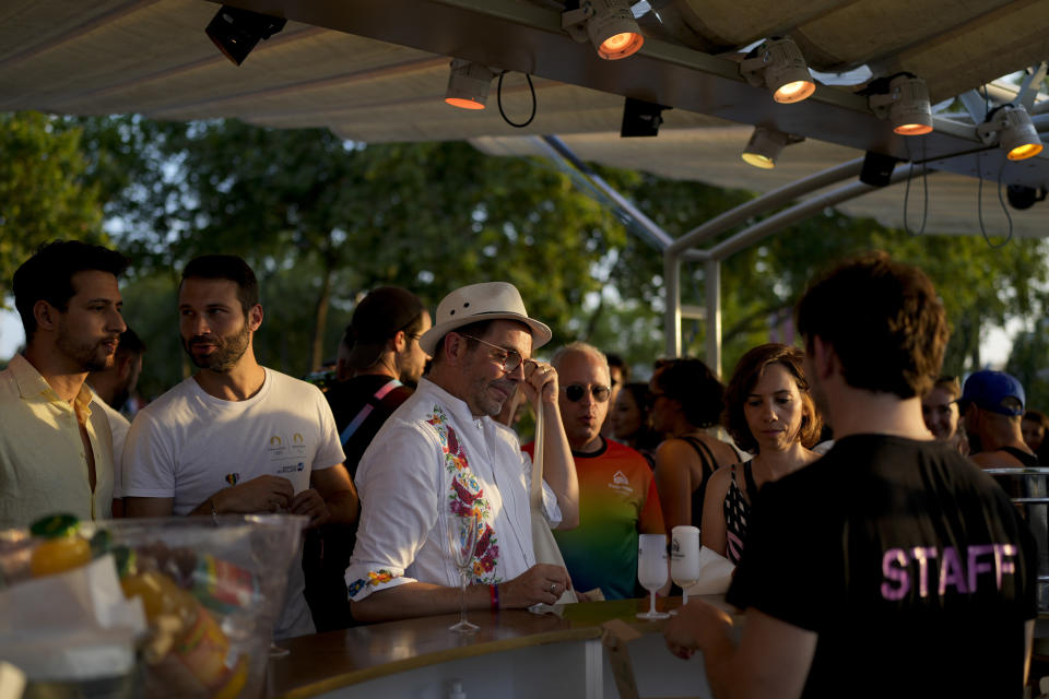 Asistentes a la inauguración de la Casa del Orgullo, el espacio seguro para la comunidad de atletas LGBT+, celebrada en el barco Rosa Bonheur sur Seine durante los Juegos Olímpicos de Verano de 2024, el lunes 29 de julio de 2024, en París, Francia. (Foto AP/Natacha Pisarenko)