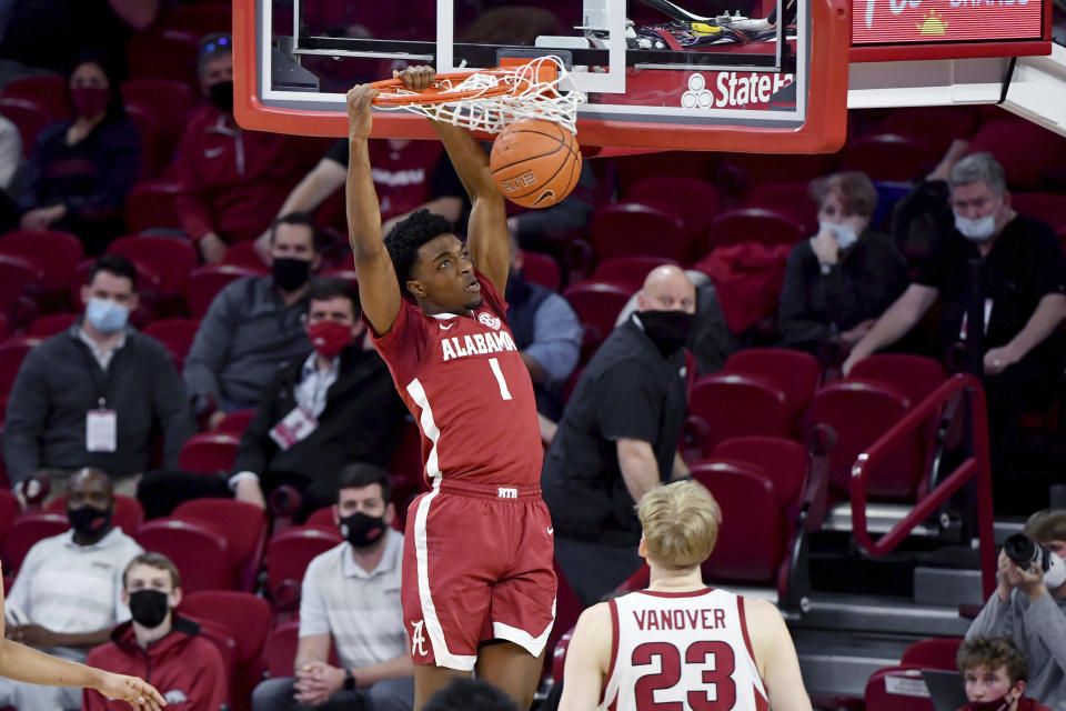 Alabama forward Herbert Jones (1) dunks the ball over Arkansas forward Connor Vanover (23) during the first half of an NCAA college basketball game in Fayetteville, Ark. Wednesday, Feb. 24, 2021. (AP Photo/Michael Woods)