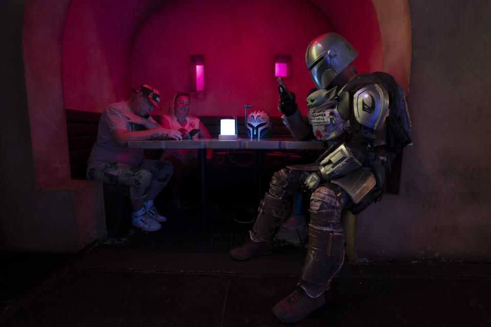 Dressed in a Star Wars costume, Tim Brehmer, right, sits in a booth as customers gather to celebrate the Star Wars Day at Scum and Villainy Cantina, a geek bar located on Hollywood Blvd, in Los Angeles, Tuesday, May 4, 2021. California has the lowest infection rate in the country. Los Angeles County, which is home to a quarter of the state's nearly 40 million people and has endured a disproportionate number of the state's 60,000 deaths, didn't record a single COVID-19 death Sunday or Monday, which was likely due to incomplete weekend reporting but still noteworthy. (AP Photo/Jae C. Hong)