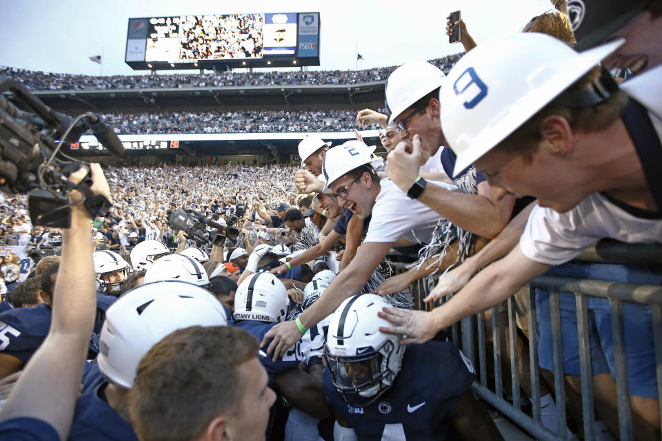 Penn State players and fans celebrate in and near the end zone after the team's win over Appalachian State in overtime in an NCAA college football game in State College, Pa., Saturday, Sept. 1, 2018. Penn State won 45-38. (AP Photo/Chris Knight)