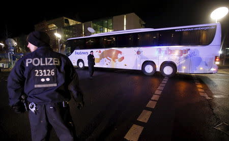 Police escort a bus carrying refugees from the Bavarian town of Landshut after it left the Chancellery building in Berlin, Germany, January 14, 2016. REUTERS/Fabrizio Bensch