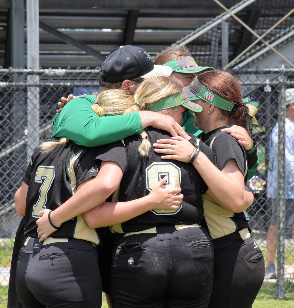 Jupiter coaches Steve Ahern and Bailey Phillips embrace Jupiter seniors Sophia White, Samantha White, and Amanda Lieberman following the regional final contest against Wellington (May 20, 2023).