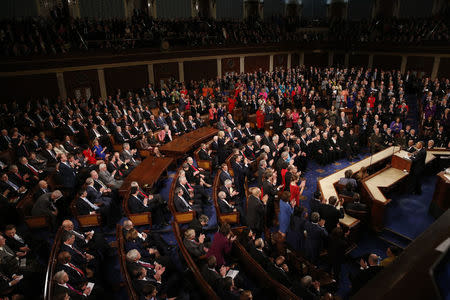 Democratic members of Congress rise to their feet for a standing ovation as Republican members remain seated during U.S. President Barack Obama's State of the Union address to a joint session of Congress in Washington, January 12, 2016. REUTERS/Jonathan Ernst