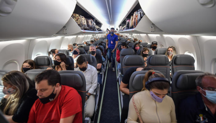 Passengers take their seats before take off in a Boeing 737 MAX aircraft operated by low-cost airline Gol at Guarulhos International Airport, near Sao Paulo on December 9, 2020, as the 737 MAX returns into use more than 20 months after it was grounded following two deadly crashes. (Photo by NELSON ALMEIDA / AFP) (Photo by NELSON ALMEIDA/AFP via Getty Images)