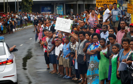 A police vehicle moves past as well-wishers stand along the street during the arrival of Britain's Prince Harry and Meghan, Duchess of Sussex, in Suva, Fiji, October 23, 2018. REUTERS/Phil Noble