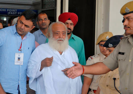 FILE PHOTO: Police escort spiritual leader Asaram Bapu (C) outside an airport after his arrest in Jodhpur, in the desert state of Rajasthan, India, September 1, 2013. REUTERS/Stringer/File Photo