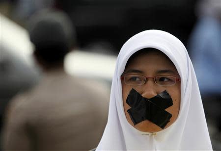 A student covers her mouth with tape during an Anti-Corruption Day rally in Jakarta in this December 9, 2009 file photo. REUTERS/Beawiharta