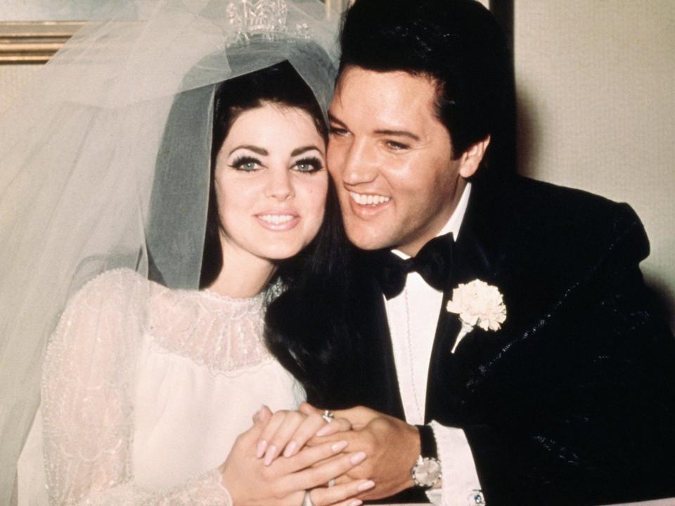 Priscilla and Elvis Presley lean their heads together on their wedding day.