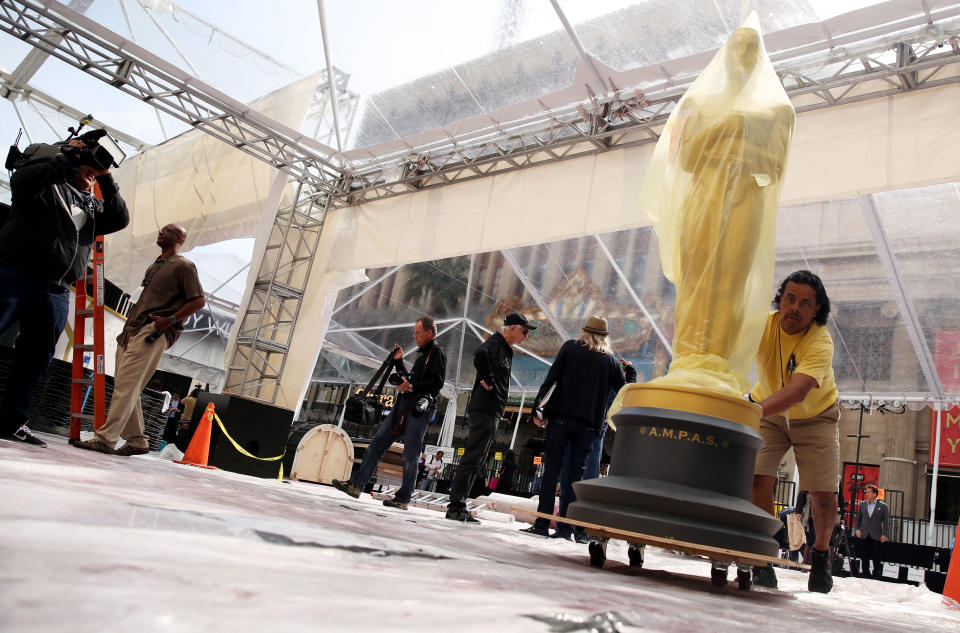 Johnny Tamayo pushes an Oscar statue as preparations are made for the 86th Academy Awards in Los Angeles, Thursday, Feb. 27, 2014. The Academy Awards will be held at the Dolby Theatre on Sunday, March 2. (Photo by Matt Sayles/Invision/AP)