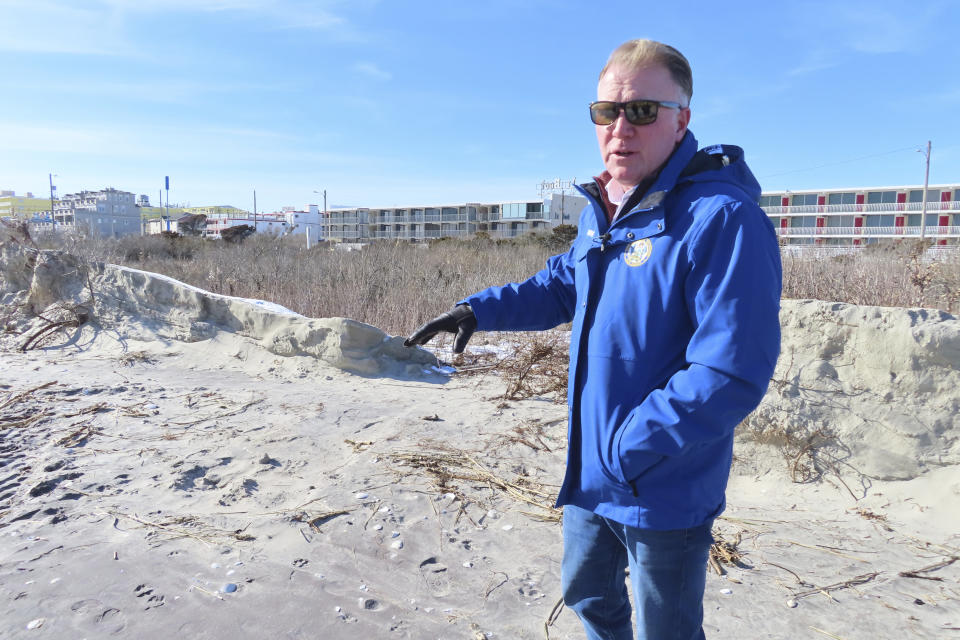 FILE - Mayor Patrick Rosenello points to a destroyed section of sand dune in North Wildwood N.J., Jan. 22, 2024. On April 25, 2024, North Wildwood and the state of New Jersey announced an agreement for an emergency beach replenishment project there to protect the city until a full-blown beach fill can be done by the U.S. Army Corps of Engineers that may still be two years away. Winter storms punched a hole through what is left of the city's eroded dune system, leaving it more vulnerable than ever to destructive flooding. (AP Photo/Wayne Parry, File)